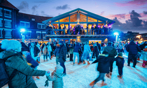 Menschen fahren Schlittschuh. Es ist fast dunkel.