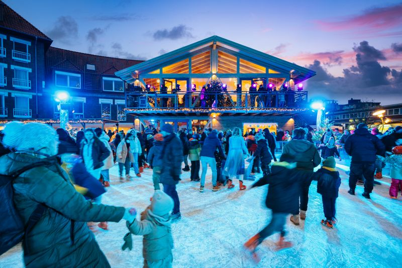 Menschen fahren Schlittschuh. Es ist fast dunkel.