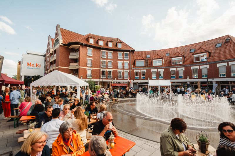 Menschen, die am Eierplatz an Biergarnituren sitzen.