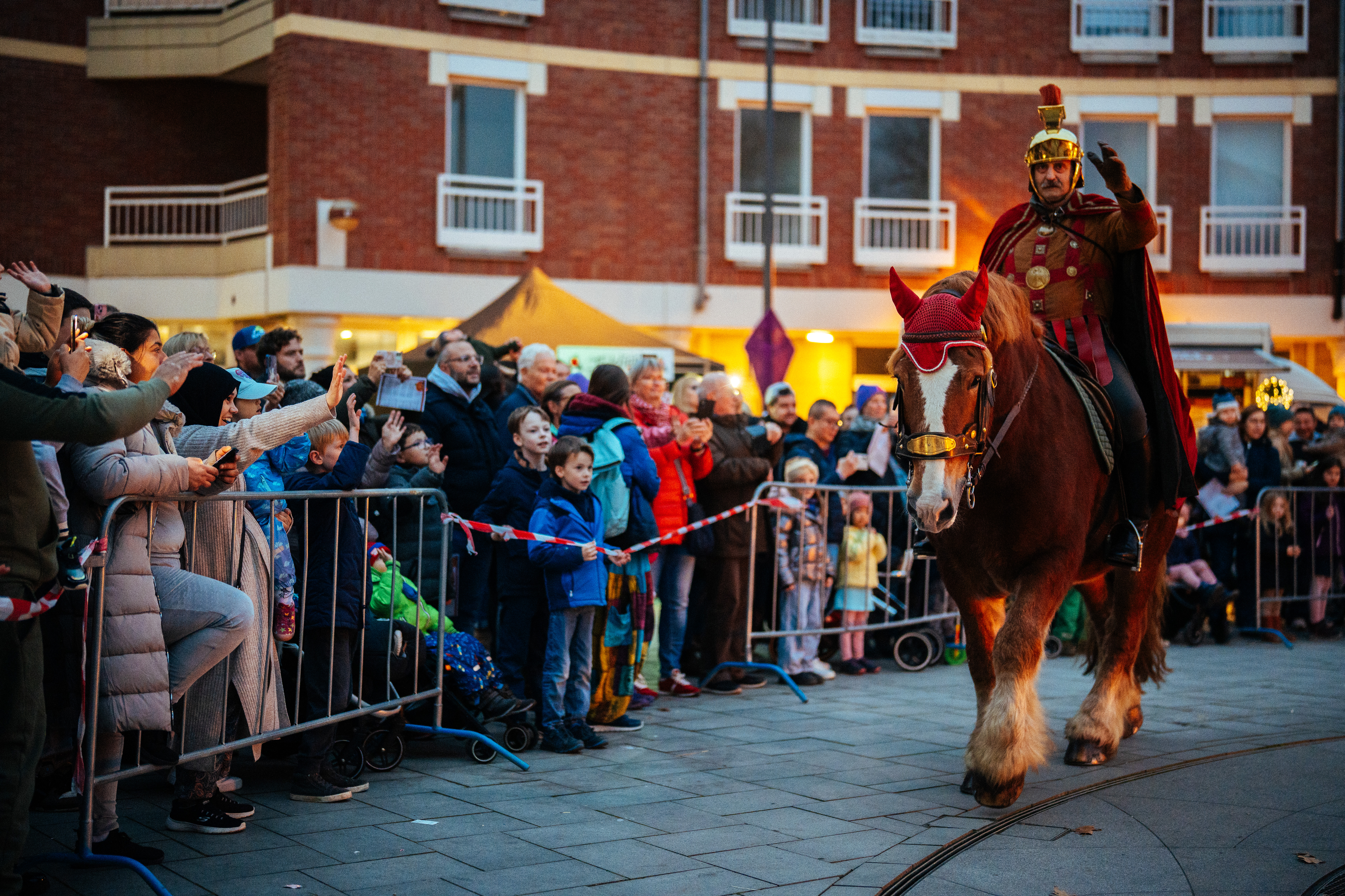 Sankt Martin auf dem Pferd reitet vorbei an Zuschauenden.