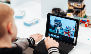 Ein Junge guckt auf sein Tablet und bearbeitet einen Lego-Trickfilm