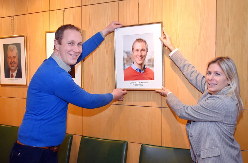 Ein Mann und eine Frau hängen ein Bild auf. 