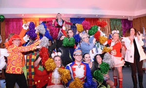 Viele bunt verkleidete Menschen formieren sich zu einer Pyramide.