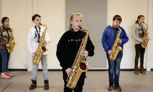 Blick auf fünf Kinder, die jeweils ein Saxophone in der Hand halten. 